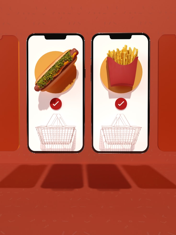A phone showing the order status next to a large pickup display screen.